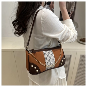 Detail of retro patchwork shoulder bag with geometric pattern and metal chain