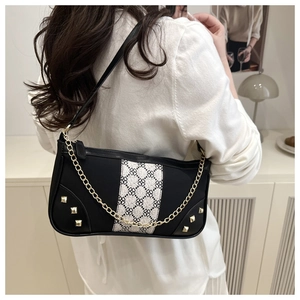 Detail view of contrast patchwork underarm bag with geometric patterns and gold studs