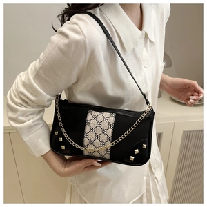Detail of retro geometric pattern fabric and gold chain on black shoulder bag