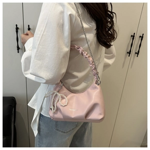 Pink pleated underarm bag with metal chain strap and pearl bow charm accessory
