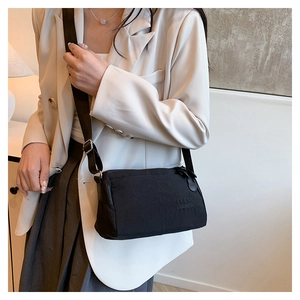 Close-up of lightweight nylon shoulder bag featuring DUONING logo and metal buckle detail