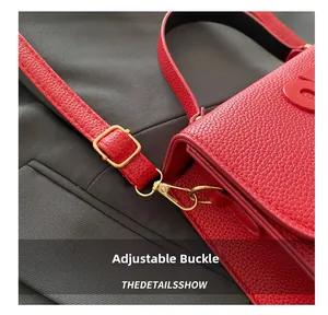 Macro detail of red lychee leather bag with gold adjustment buckle and hardware strap