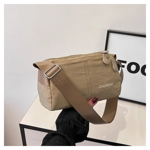 Detail of khaki nylon crossbody bag with DUONING print and double zipper closure