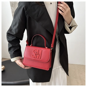 Close-up of red litchi grain leather bag with 3D SM logo and gold-tone hardware