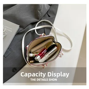 Top view of white shell bag open showing phone and cosmetics for storage capacity