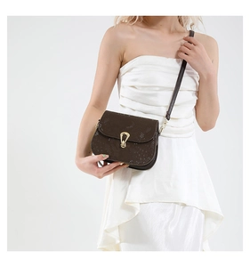 Détail du sac bandoulière marron foncé avec motif crocodile et boucle dorée chic