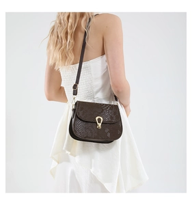 Détail du sac à bandoulière marron foncé à motif serpent et boucle dorée chic