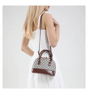 Classic shell-shaped crossbody bag with monogram texture and slim shoulder strap on model