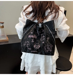 Close-up of black graffiti tote bag with pink cat doodles and crinkled texture