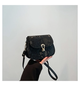 Vue détaillée du sac besace en cuir texturé serpent avec boucle en métal doré