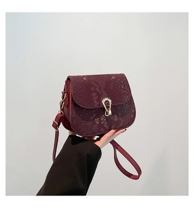 Détail du sac carré bordeaux à motif serpent avec une boucle en métal doré rétro