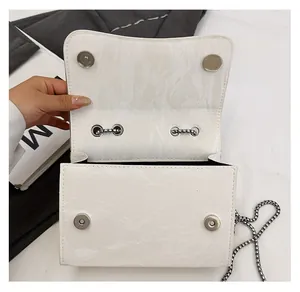 Detail showing the silver magnetic buckle closure and chain of the marble pattern bag