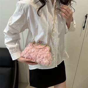 Pink 3D floral evening bag with golden chain strap shown on model for elegant look