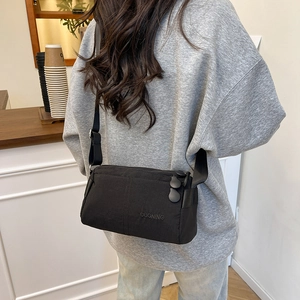 Lightweight black waterproof crossbody bag with multiple compartments shown on a model