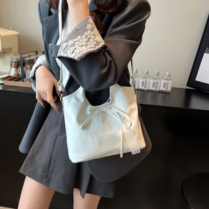 Elegante bolso de mano crema con gran lazo de encaje y correa de hombro delgada