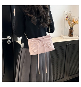 Detailed view of a sweet pink PU leather tote with a large bow and gold chain strap