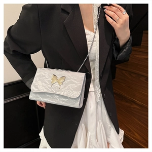 Detail of silver metallic butterfly shoulder bag with chain strap and crinkled texture