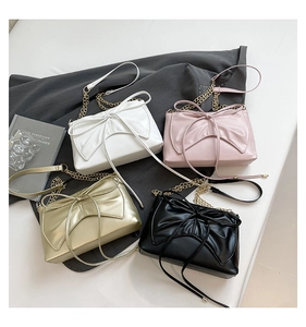 Detail showing various colors of mini square bags with large bows and chain straps