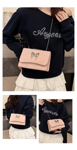 Detail of pink pleated chain bag featuring a silver metal butterfly ornament and magnetic flap