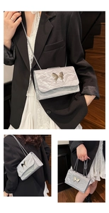 Detail of silver crinkled texture underarm bag with decorative metal butterfly buckle