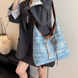 Grande borsa tote in denim blu con cinturini in pelle marrone e fiocco per il lavoro