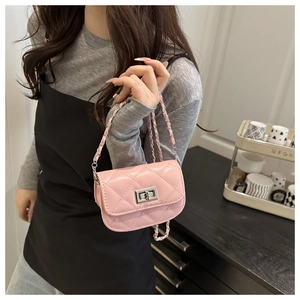 Detail of a pink quilted mini bag with silver twist lock and chain strap on a model