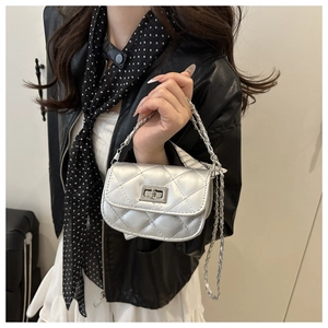 Detail of silver quilted mini crossbody bag with metal chain strap and twist lock
