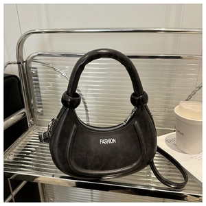 Détail du sac bandoulière en demi-lune avec logo FASHION sur support métal