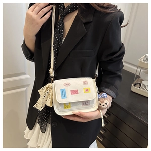 Detail of white square crossbody bag with cute stickers and plush bear charm