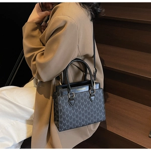 Détail d'un sac cabas élégant avec monogramme et lettrage doré sur cuir texturé de qualité