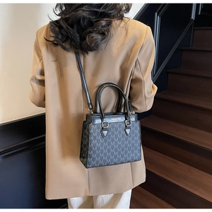 Sac à main noir chic avec motif monogramme et bandoulière en cuir réglable sur modèle