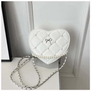Detail of white heart crossbody bag with quilted lattice, pearls and silver bow accent