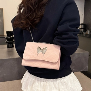 Chic pink textured leather butterfly shoulder bag with silver chain strap on model
