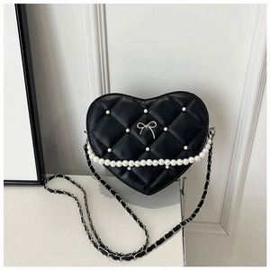 Detail of heart-shaped quilted bag with pearl embellishments and metal bow buckle