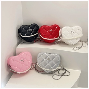 Detail of heart-shaped crossbody bags with quilted pattern and pearl decorations
