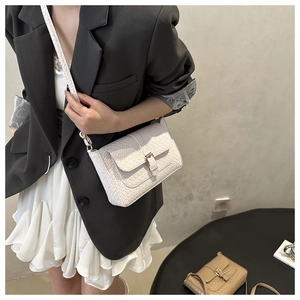 Detail of white textured small square bag with gold-tone buckle and slim shoulder strap