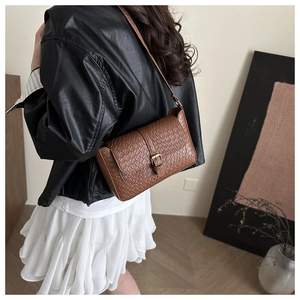 Brown woven texture handbag featuring gold pin buckle and slim shoulder strap on model