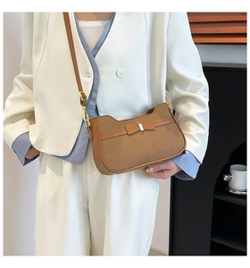 Borsa marrone intrecciata con fiocco in pelle abbinata a un blazer bianco