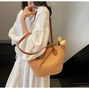 Détail du sac cabas en paille tissée avec poignées en similicuir brun et tulipe
