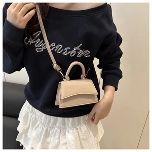 Chic beige lychee leather small square bag styled with casual urban outfit and long strap