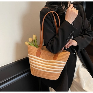 Détail du sac cabas tissé avec rayures blanches et bandoulières en cuir marron