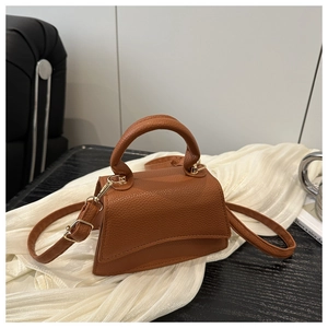 Detail view of the caramel lychee pattern leather mini bag with curved bottom design