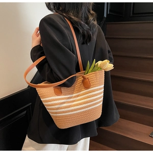 Détail du sac cabas tissé avec rayures kaki et blanches et bandoulières en cuir marron
