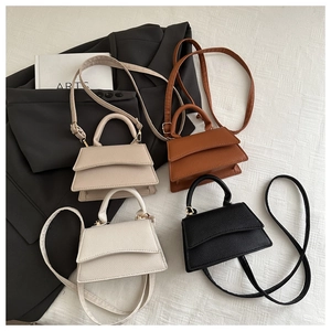 Group display of mini trapezoid crossbody bags in four colors with gold-tone hardware