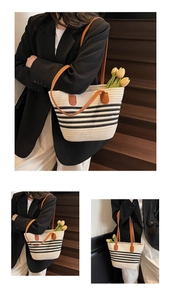 Détail d'un sac cabas tissé crème avec rayures noires et anses en cuir marron foncé