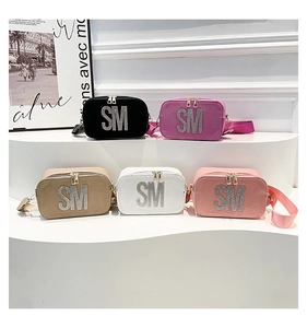 Detailed row of various textured PU leather camera bags featuring sparkling rhinestone letters