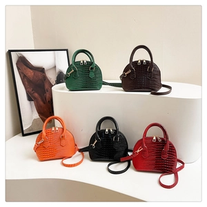 Collezione di borse a conchiglia motivo coccodrillo in verde, marrone, arancio e nero