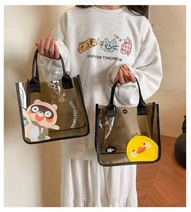 Détail de sacs transparents en PVC marron avec motifs de panda et canard cartoon