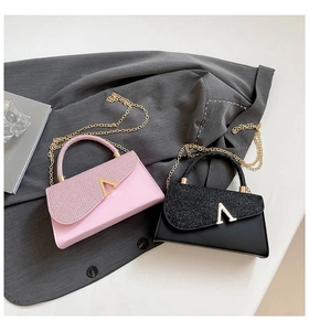 Detail of pink and black glitter mini evening bags with V-shaped metal buckle and gold chain
