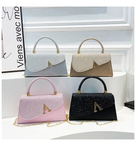 Close-up of glitter evening bags with V-shaped gold buckles and delicate chain straps